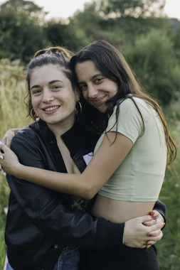 A photograph of two young people hugging in nature