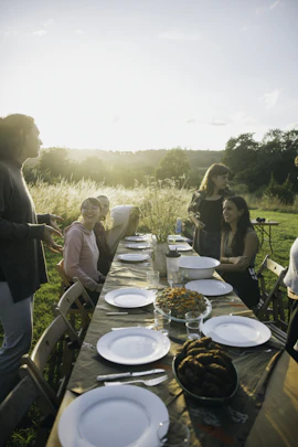 A group of young people sharing food at sunset.